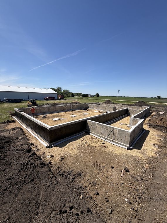 Full residential foundation footprint poured on an open rural site