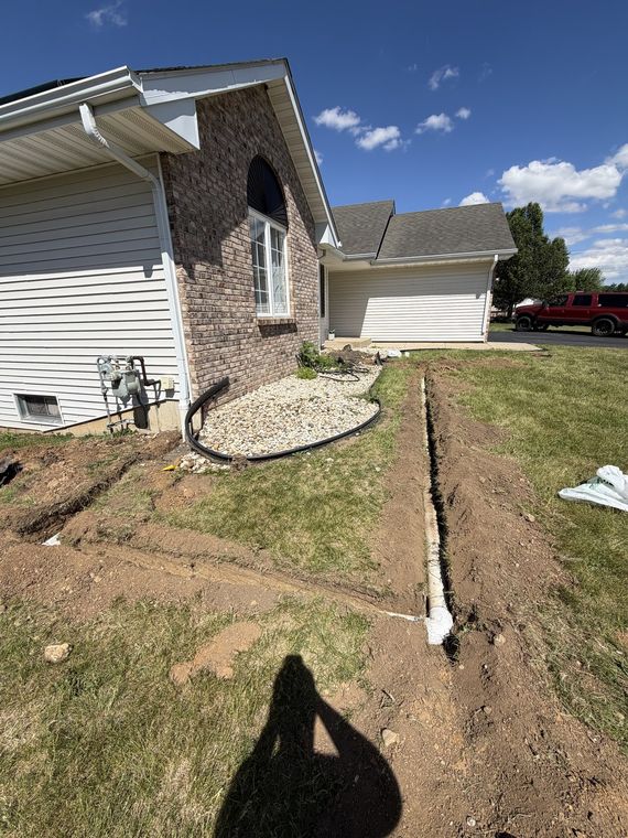 Downspout drain line trenched across a front yard to daylight