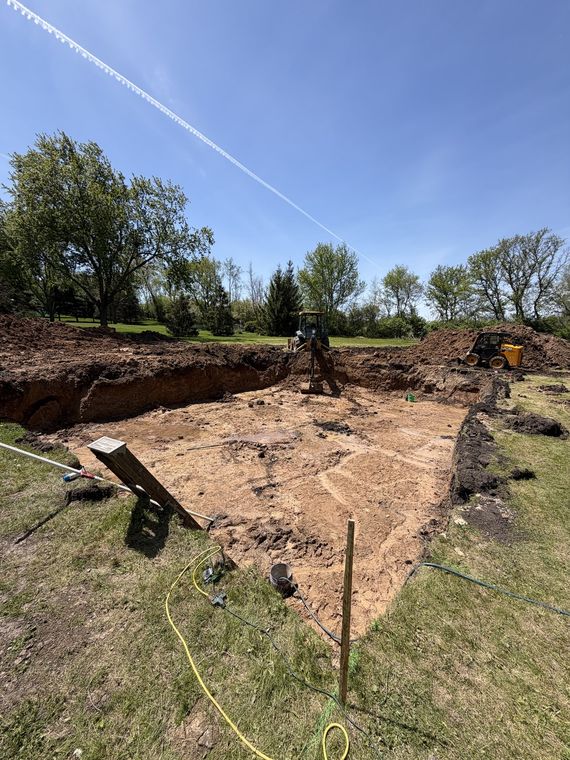 Open footing excavation staked out for a new building foundation