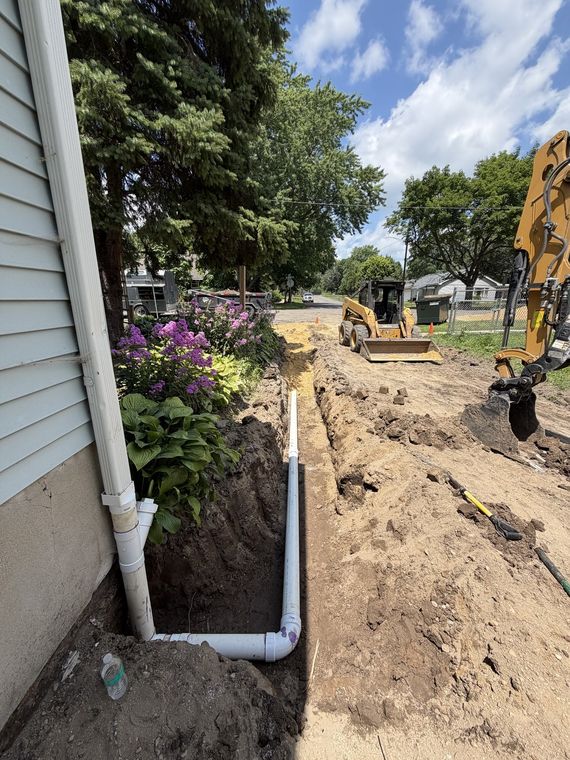 New downspout drain line piped down to the foundation of a house