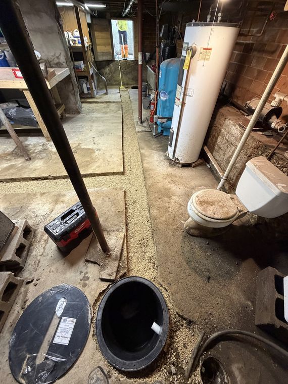 Basement sewer line trench opened alongside the water heater